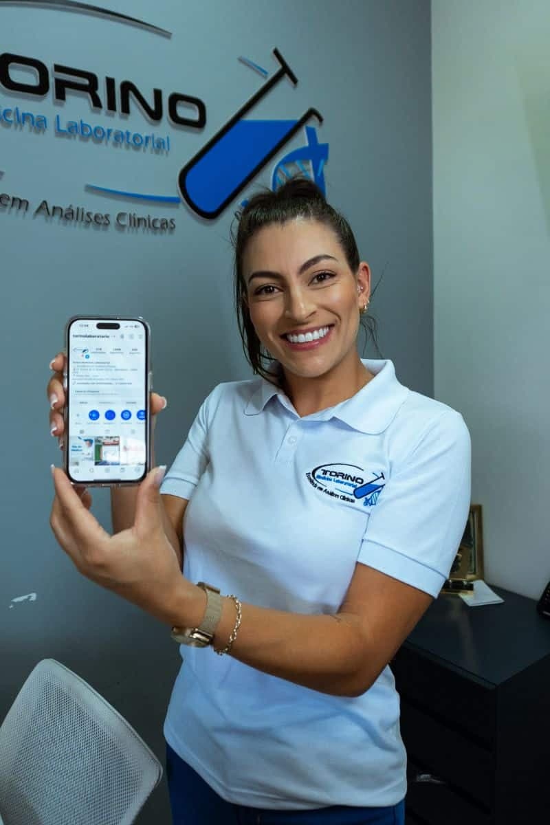 Profissional mostrando o portal de resultados no celular